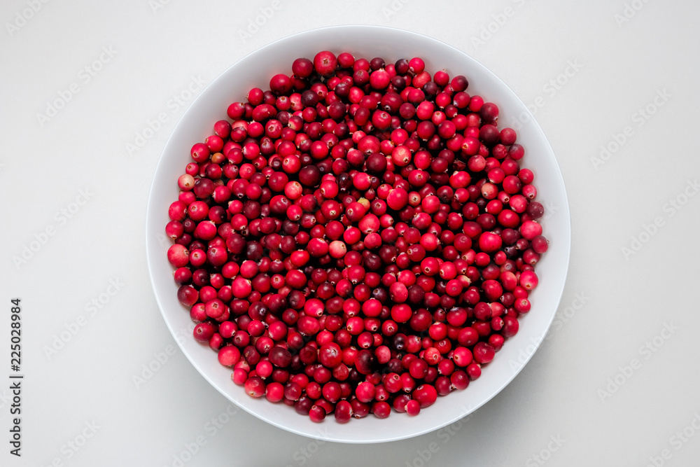 white bowl with cranberries on white table white bowl with cranberries on white table