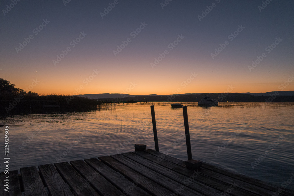 Obraz premium Sunset in Switzerland, view of the Lake Murten, moon rising and sun setting