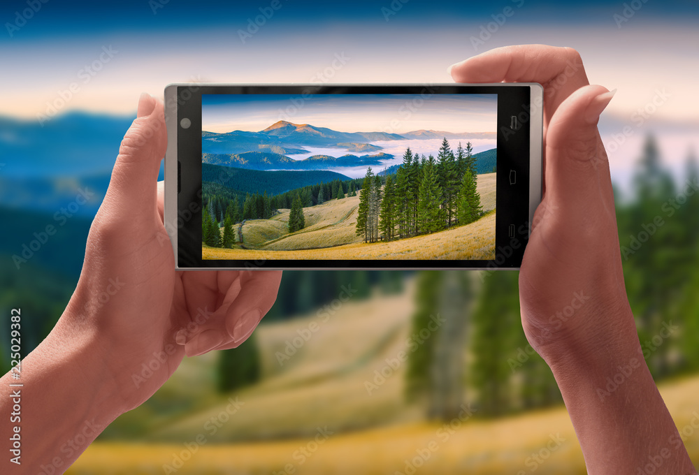 Panorama of Carpathian mountain valley on a screen of smartphone