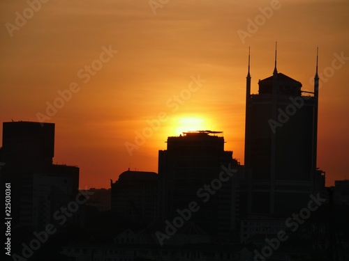 The sun sets over the silhouettes of buildings and skyscrapers in Saigon.