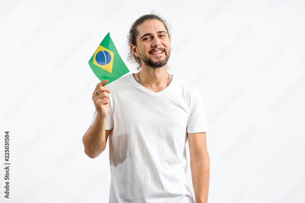 Young man with the flag of Brazil. Fan male holding flag of Brazil on light background. Patriot. Young man with the flag of Brazil. Fan male holding flag of Brazil on light background. Patriot.
