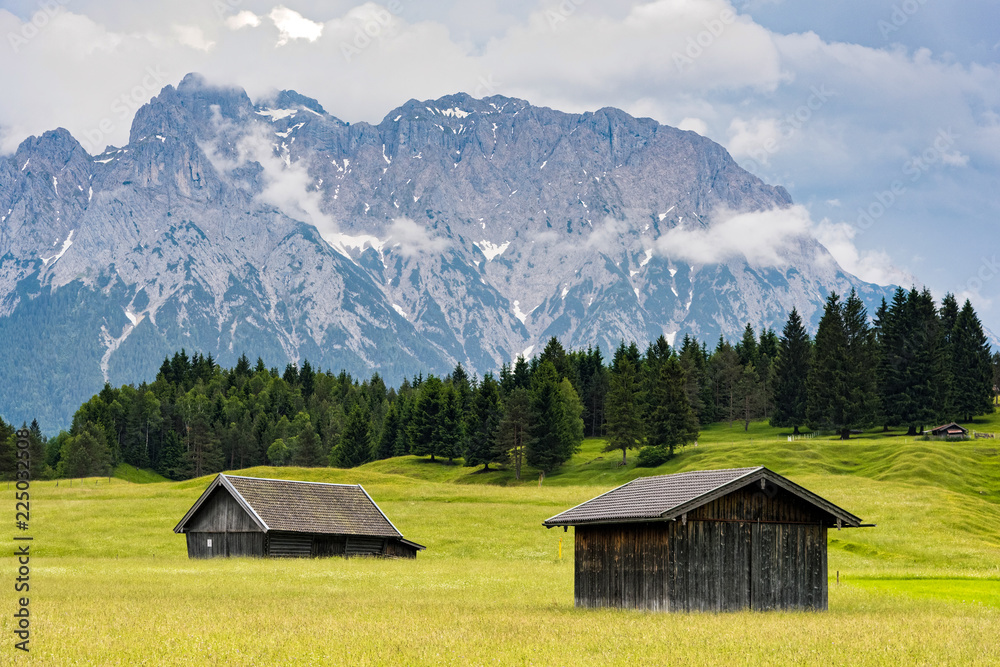 Obraz premium Wooden huts near Zugspitze, the highest mountain of Germany at the Bavarian Alps