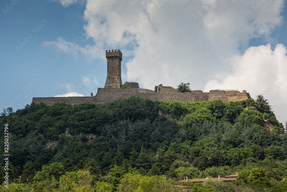 Small walled hilltop town with a square tower in Tuscany, Italy