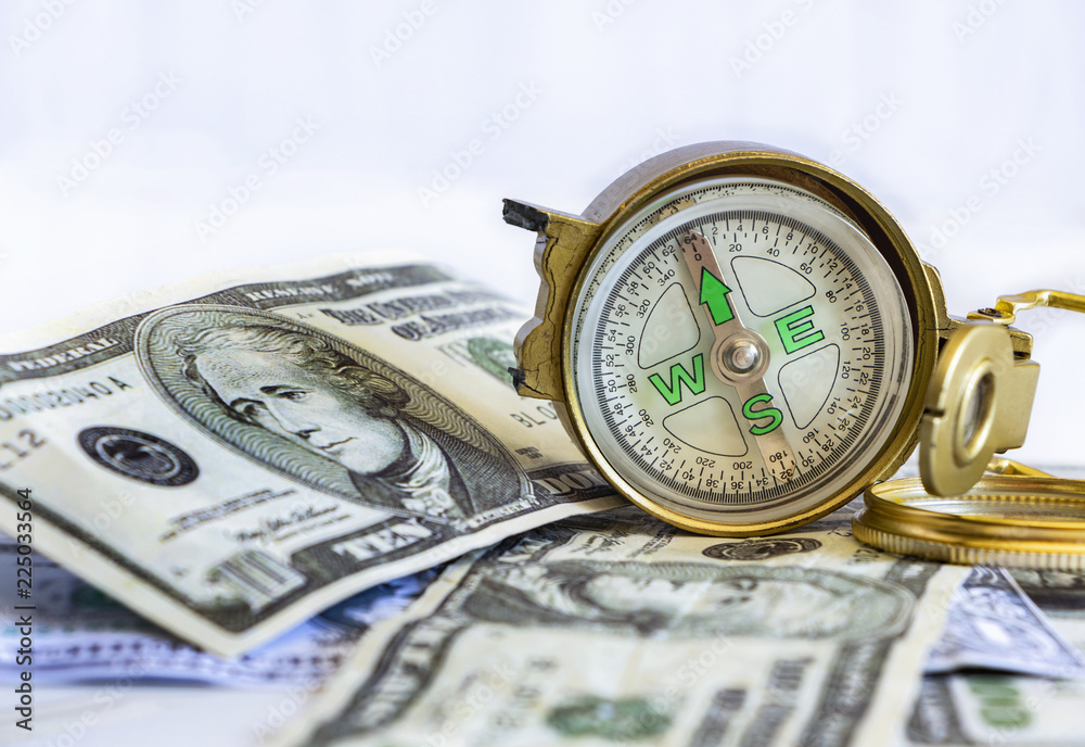 Defective compass placed on the United States dollar banknotes. The concept of direction of financial or investment at present and in the future. Defective compass placed on the United States dollar banknotes. The concept of direction of financial or investment at present and in the future.