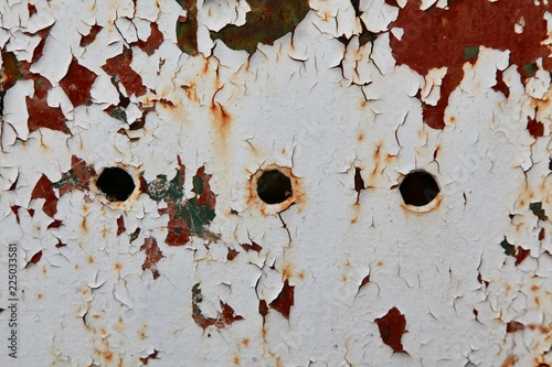 Old wall with peeling paint with three holes
