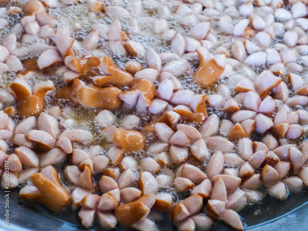 Fried sausages in boiling oil in a saucepan. Fried sausages in boiling oil in a saucepan.