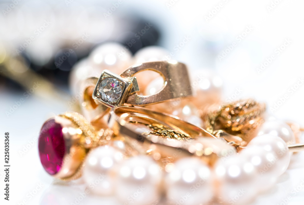Real gold jewlery, diamonds, gems, rings, neckless with pearls close up shot , white background, on shiny surface. Real gold jewlery, diamonds, gems, rings, neckless with pearls close up shot , white background, on shiny surface.