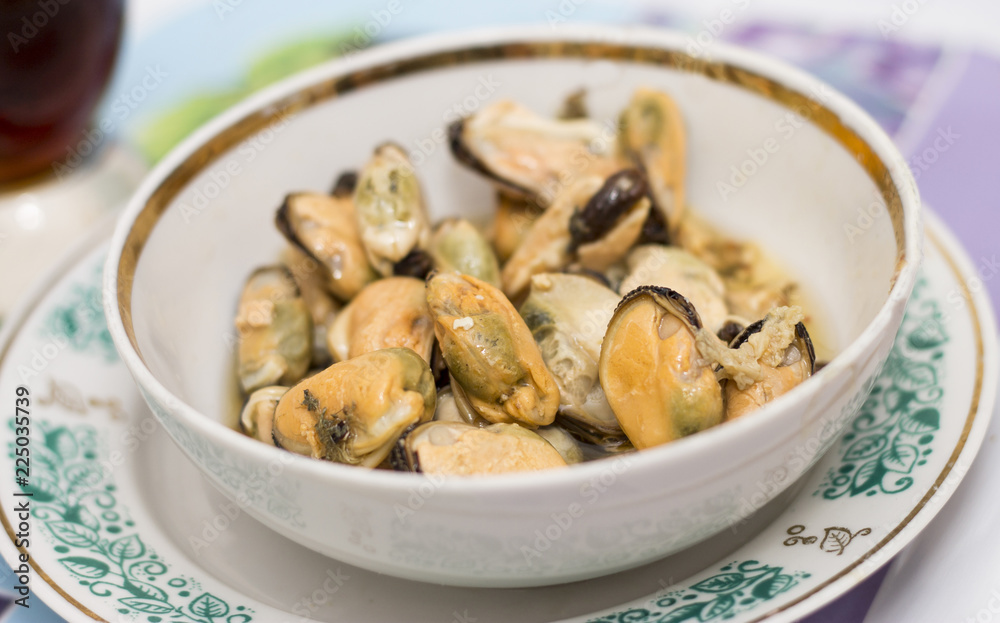 Tasty oiled pickled mussels iin a plate on the table Tasty oiled pickled mussels iin a plate on the table