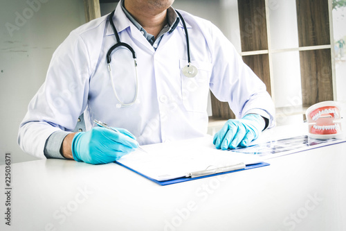 After the examination, the young man's teeth are healthy and he makes an appointment for the next tooth. photo