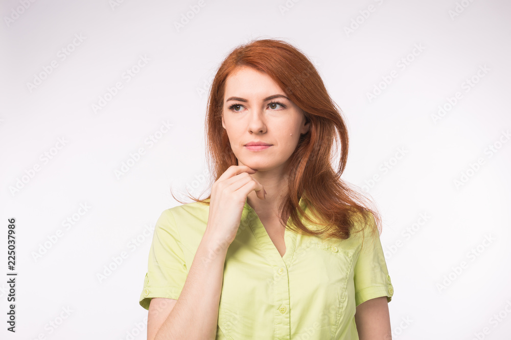 Thoughtful sad woman with red hair on white background Thoughtful sad woman with red hair on white background