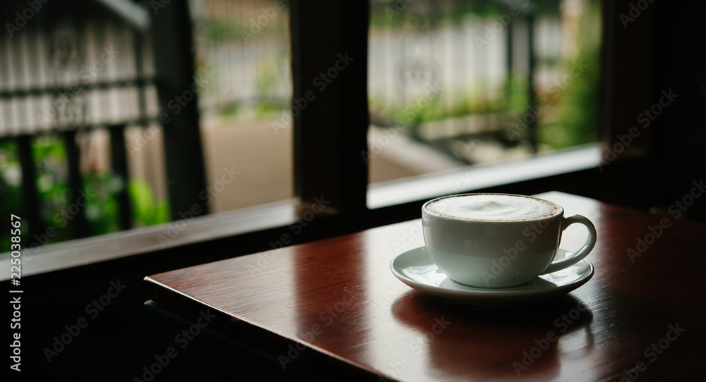 Hot Coffee in a cup on wooden table and morning light Hot Coffee in a cup on wooden table and morning light