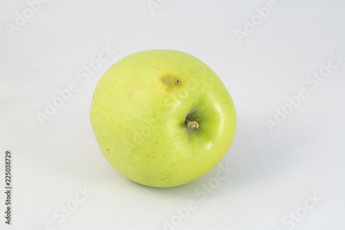 Bad green apple on white background