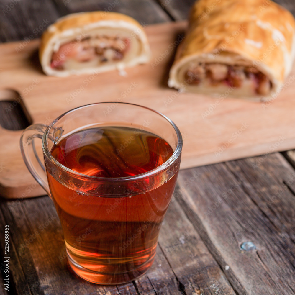 Apple strudel on wooden board served with tea Apple strudel on wooden board served with tea