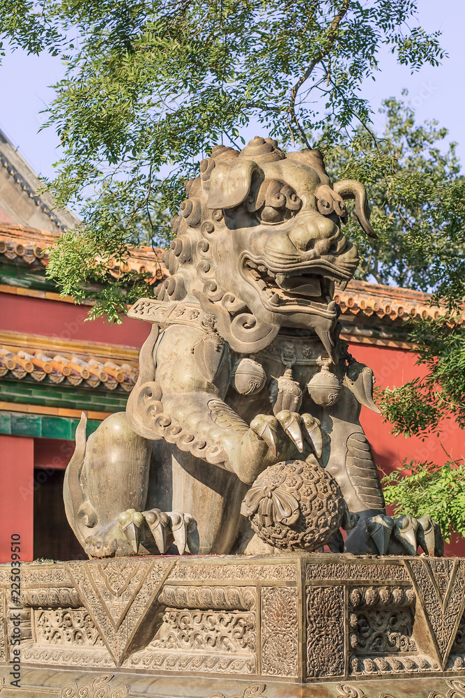 Fototapeta premium Guardian Lion in front of an ornamented pavilion at Yonghe Lamasery, also known as Lama Temple, monastery of the Gelug school of Tibetan Buddhism located in Dongcheng District.
