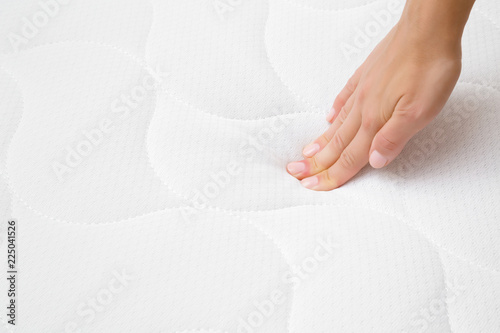 Foto Woman's hand pressing on white mattress