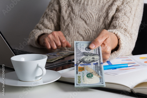 Money from USA. Dollars. Person giving papernotes on desk. photo