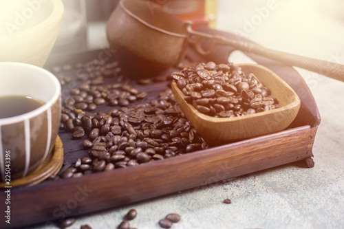 Coffee beans in a wooden Bowl on the wooden floor.