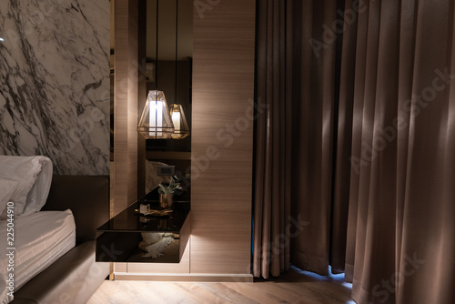 working corner decorated with books and artificial plant in gold collar glass vase on gray spray painted warbrobe / cozy interior concept / isolated for advertising photo