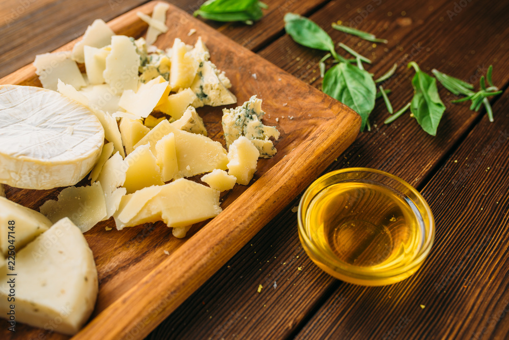 Cheese, oil and herb on wooden table closeup Cheese, oil and herb on wooden table closeup