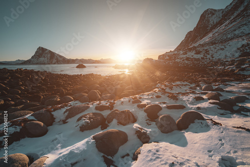 Landscape with beautiful winter sunset and snowy boulders at Lofoten Islands in Northern Norway.