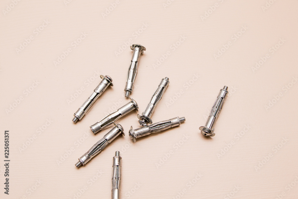 Wall plug or anchor or rawlplug on a wooden background Wall plug or anchor or rawlplug on a wooden background