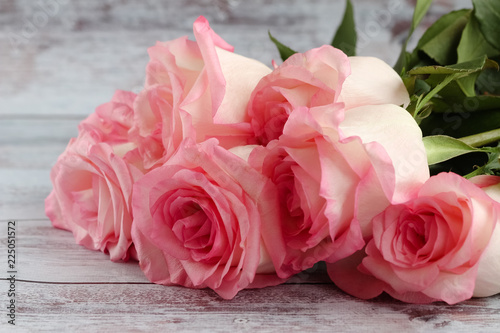 Beautiful bunch of pink roses lies on a light background. 