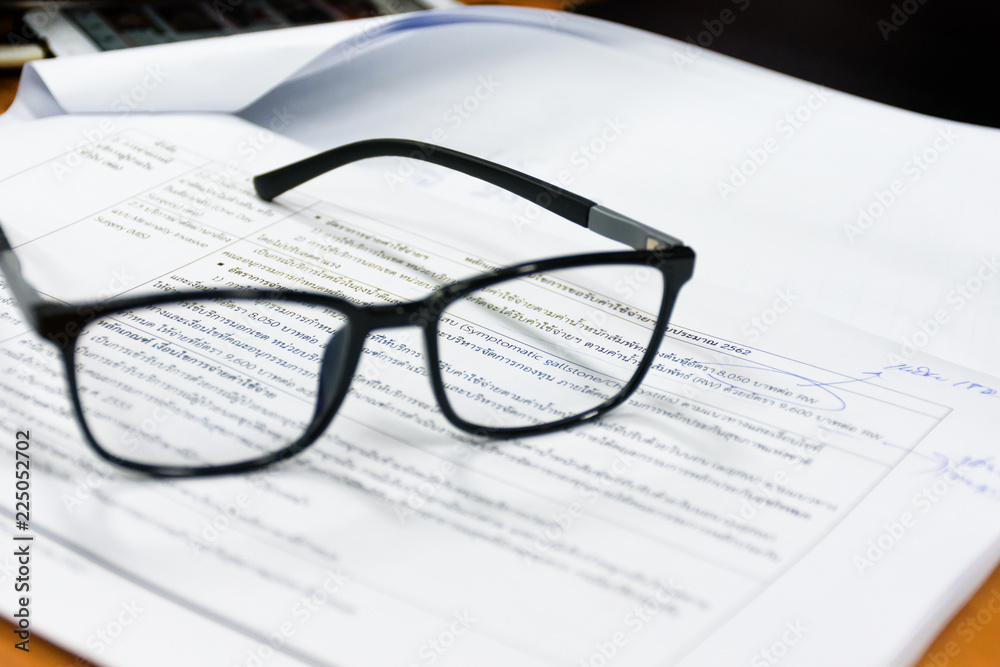 View through reading glasses. Reading glasses on the paper sheet. View through reading glasses. Reading glasses on the paper sheet.