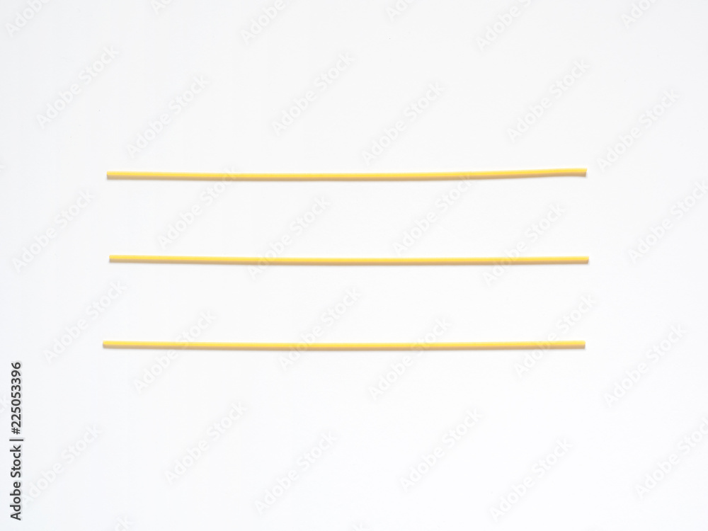 Dry spaghetti on a white background for the menu. Geometric background. Flat lay, copy space, top view Dry spaghetti on a white background for the menu. Geometric background. Flat lay, copy space, top view