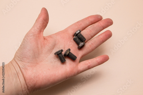 Bolt in the hand on a wooden background