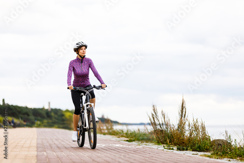 Fototapeta Naklejka Na Ścianę i Meble -  Young woman and bike at seaside