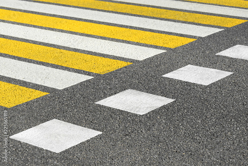 Asphalt road crosswalk with marking lines white and yellow stripes. Road marking pattern.