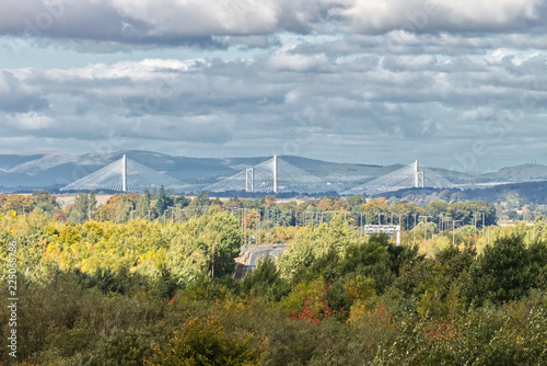 A photograph of the new Queensferry bridge over the Firth of Forth near Edinburgh, Scotland, UK, also showing the county of Fife and a forest changing colour in the fall.  © Thomas