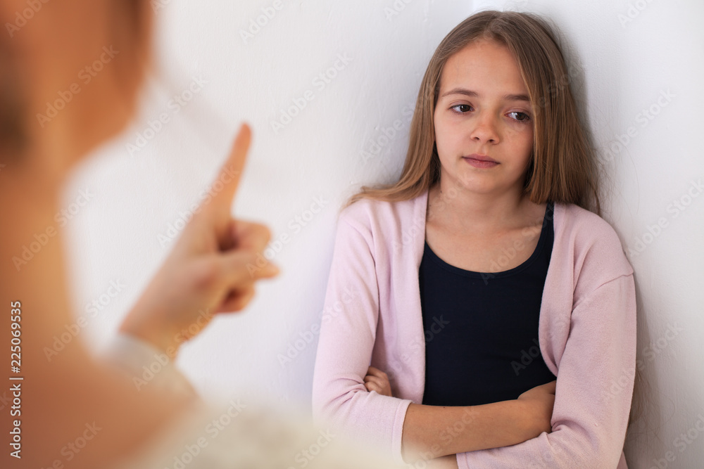 Woman lecturing her bored teenager daughter - pointing with finger Woman lecturing her bored teenager daughter - pointing with finger