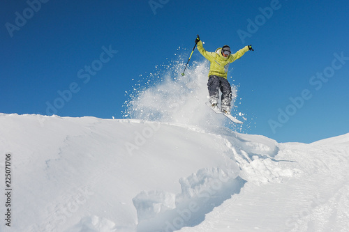 Active skier in yellow sportswear riding down the slope in Georgia, Gudauri