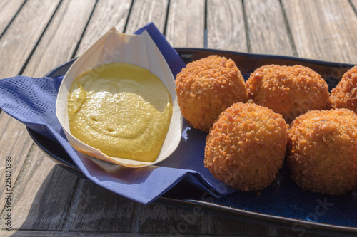 Tasty fried meat balls, served with mustard in a beach restaurant. Typical and delicious dutch food snack, bitterballen