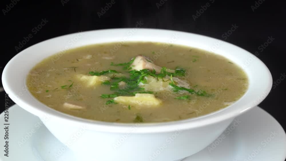 Vegetable soup with mushrooms and potatoes. Healthy food, mushrooms soup in white plate, close up, rotates Vegetable soup with mushrooms and potatoes. Healthy food, mushrooms soup in white plate, close up, rotates