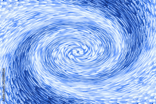 Space matter revolves around a spiral wormhole of cobalt color. Fantastic background image of asymmetric vortex tunnel in center of shot in blue.
