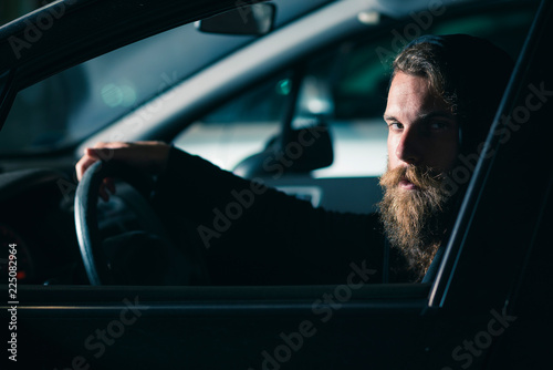 Φωτογραφία Man with beard and long hair in a car