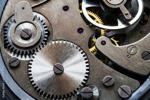 Mechanism of old mechanical watches with a pendulum, gears and other details. Selective focus.