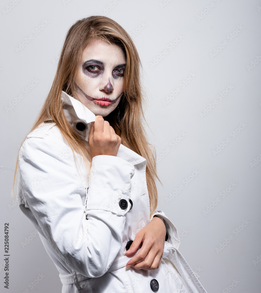 girl in a white coat on a white background with Halloween makeup girl in a white coat on a white background with Halloween makeup