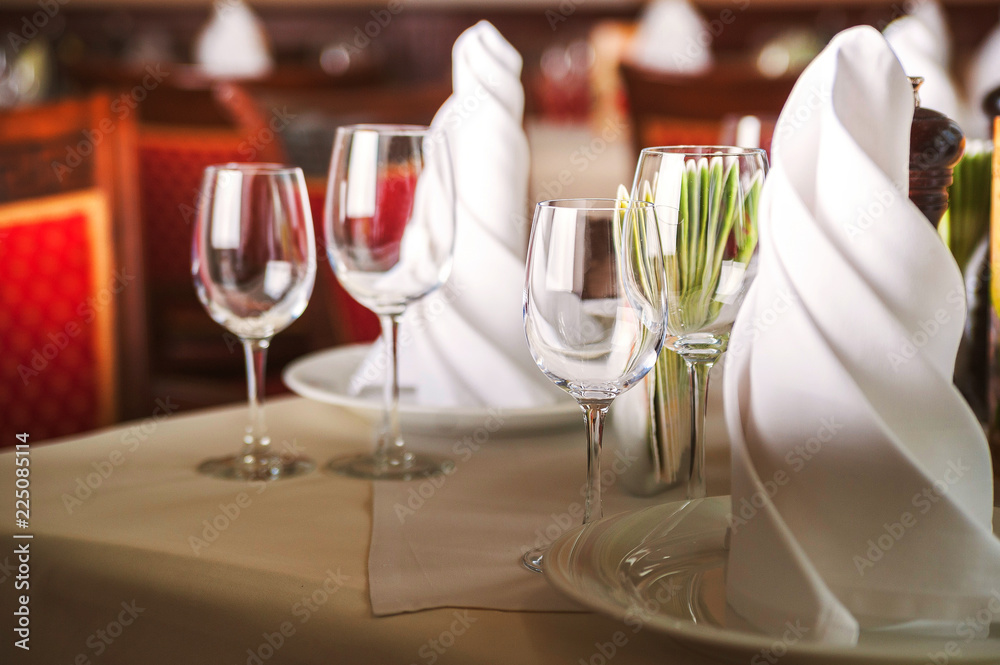 The concept of rest in a restaurant, cafe. Empty wine glasses on a table with a white tablecloth. Easy photo tinting