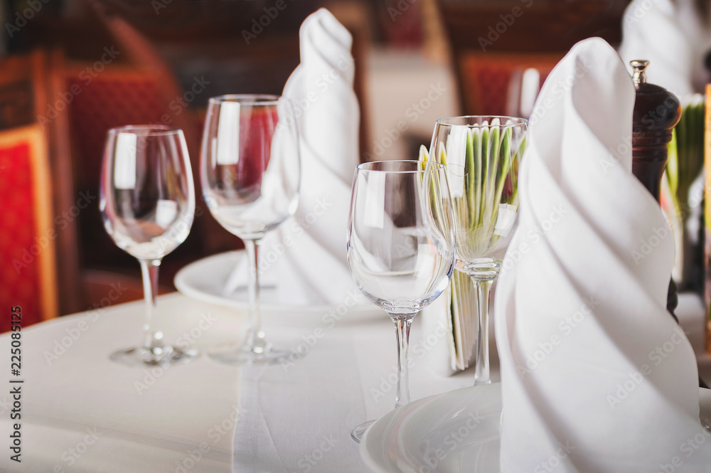 The concept of rest in a restaurant, cafe. Empty wine glasses on a table with a white tablecloth. Easy photo tinting The concept of rest in a restaurant, cafe. Empty wine glasses on a table with a white tablecloth. Easy photo tinting