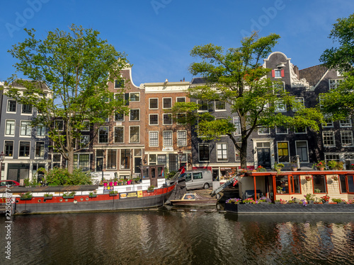 Buildings and boats along Amsterdam's beautiful  canals in central Amsterdam during the day. The canals are one of Amsterdam's main attractions.