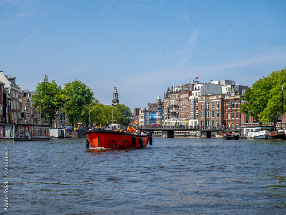 Buildings and boats along Amsterdam's beautiful  canals in central Amsterdam during the day. The canals are one of Amsterdam's main attractions.