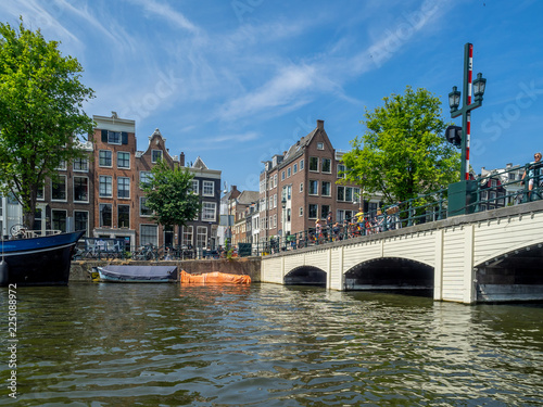 Buildings and boats along Amsterdam's beautiful  canals in central Amsterdam during the day. The canals are one of Amsterdam's main attractions.