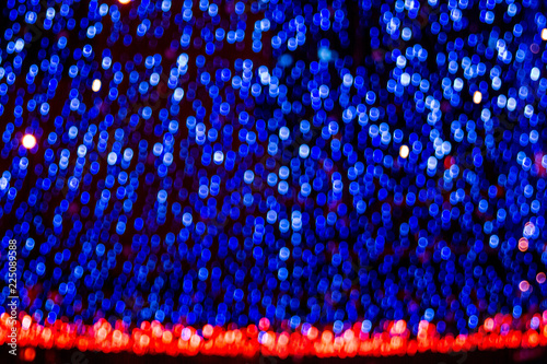 Bokeh-abstraction: glowing luminous blue theater curtain with fiery red edging