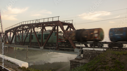 Early in the morning, when the street is foggy, the train is riding on the railway bridge © maykal