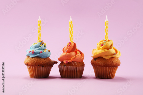 Tasty cupcakes on pinke background. Birthday cupcake in rainbow colors.