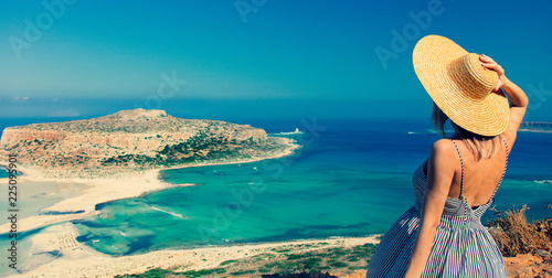 Bilde på lerret Young redhead girl in hat and dress with sea coastline on Balos, Crete, Greece