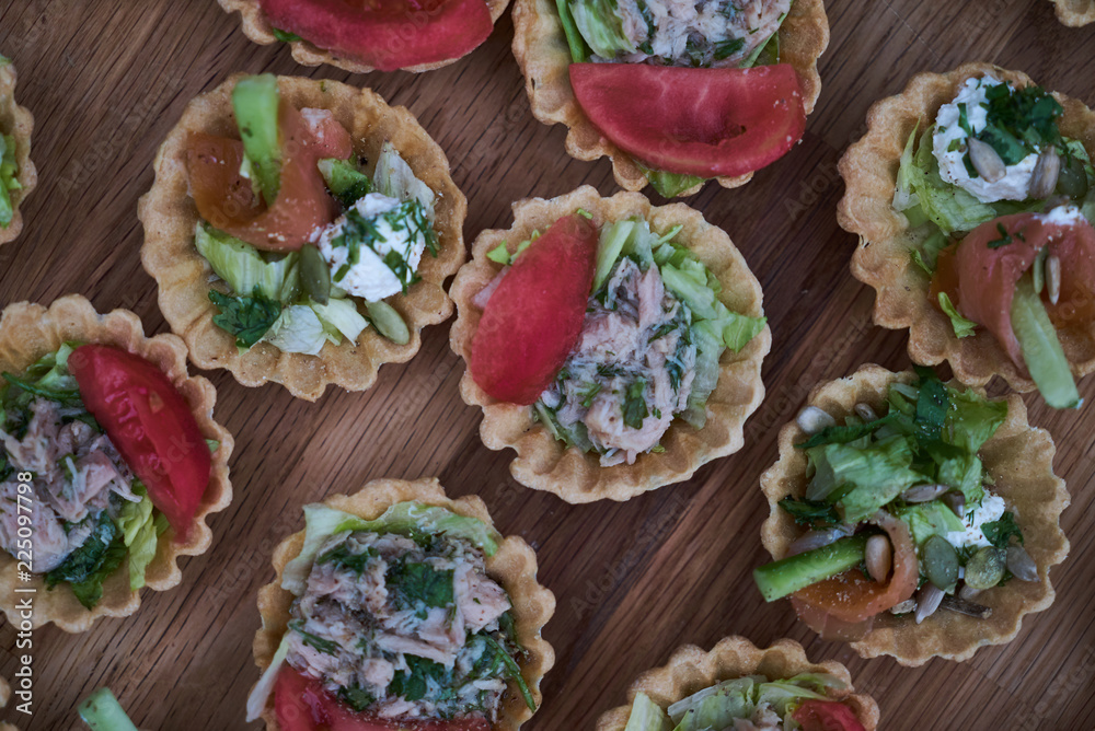 Delicious crispy tartlets or cake tarts with cream cheese and vegetables, top view, close-up Delicious crispy tartlets or cake tarts with cream cheese and vegetables, top view, close-up